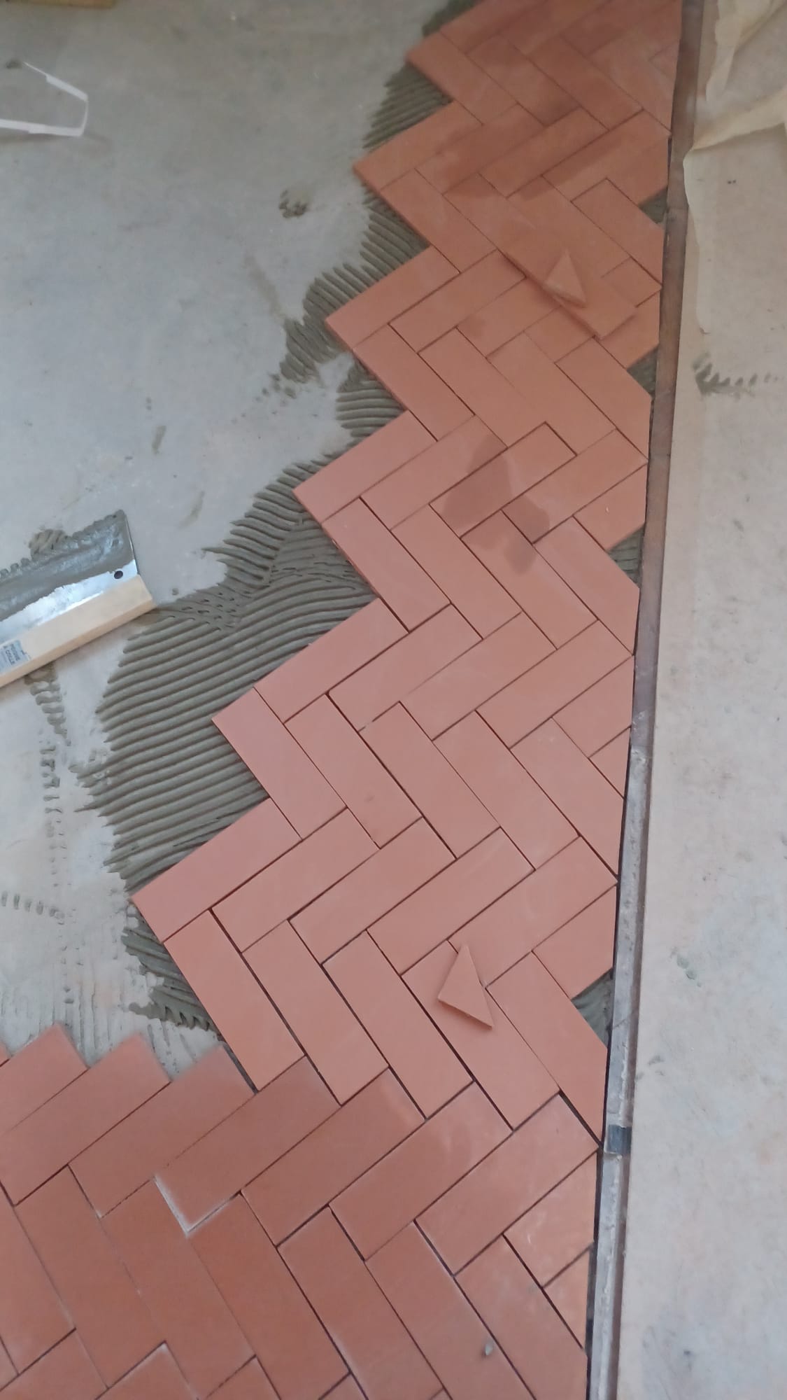 Pose de carrelage en motif Herringbone - Juganu Rénovation - Nous nous engageons à transformer vos idées en réalisations concrètes, assurant le succès et les délais de chaque projet. Notre expertise dans le secteur du bâtiment nous permet de vous offrir des solutions sur mesure, combinant innovation et qualité. 